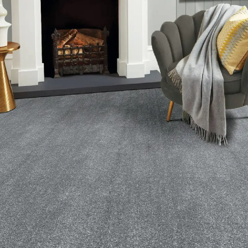 charcoal grey fireproof carpet installed in a living room setting next to a dark hearth