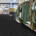 Black grid-patterned fireproof carpet in a modern retail clothing store.