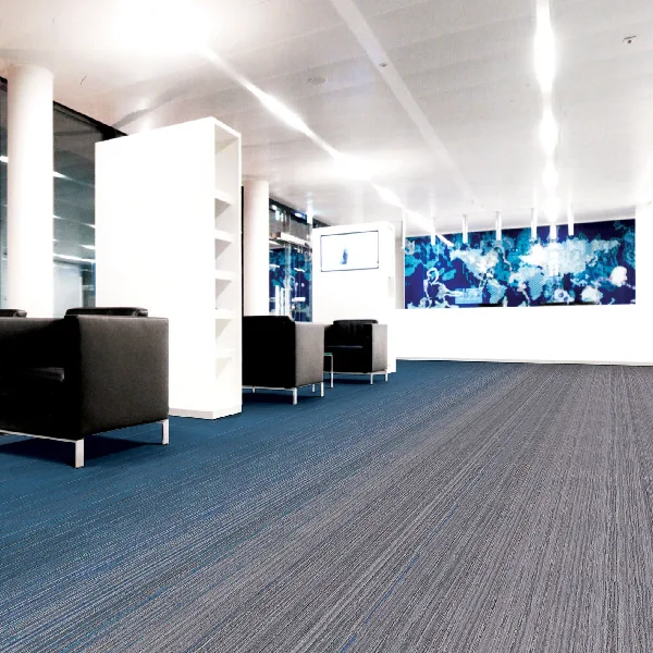 Blue and grey linear loop carpet tiles in a modern office reception.