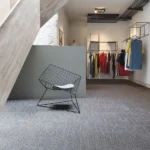 Grey textured fireproof carpet tiles in a minimalist fashion boutique.