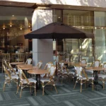 Grey textured fireproof carpet tiles in an outdoor cafe seating area.