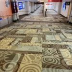 Multi-colored patterned fireproof carpet in an airport hallway.