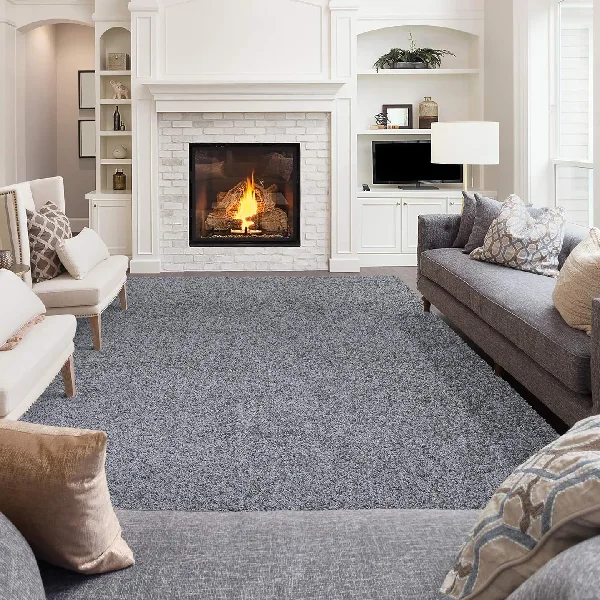 Plush grey frieze carpet in a modern living room with a fireplace.