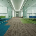 Striped fireproof carpet tiles in a modern glass office interior.